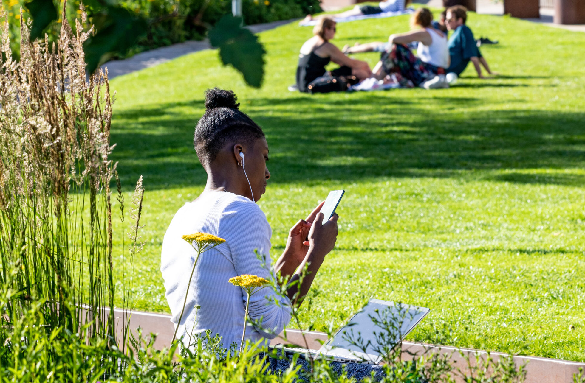 A man sat in a park, listening to his personal stereo