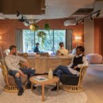 a man and woman sat on arm chairs in a co-living space