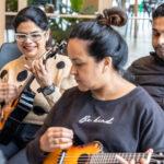 Adults playing with a Ukelele