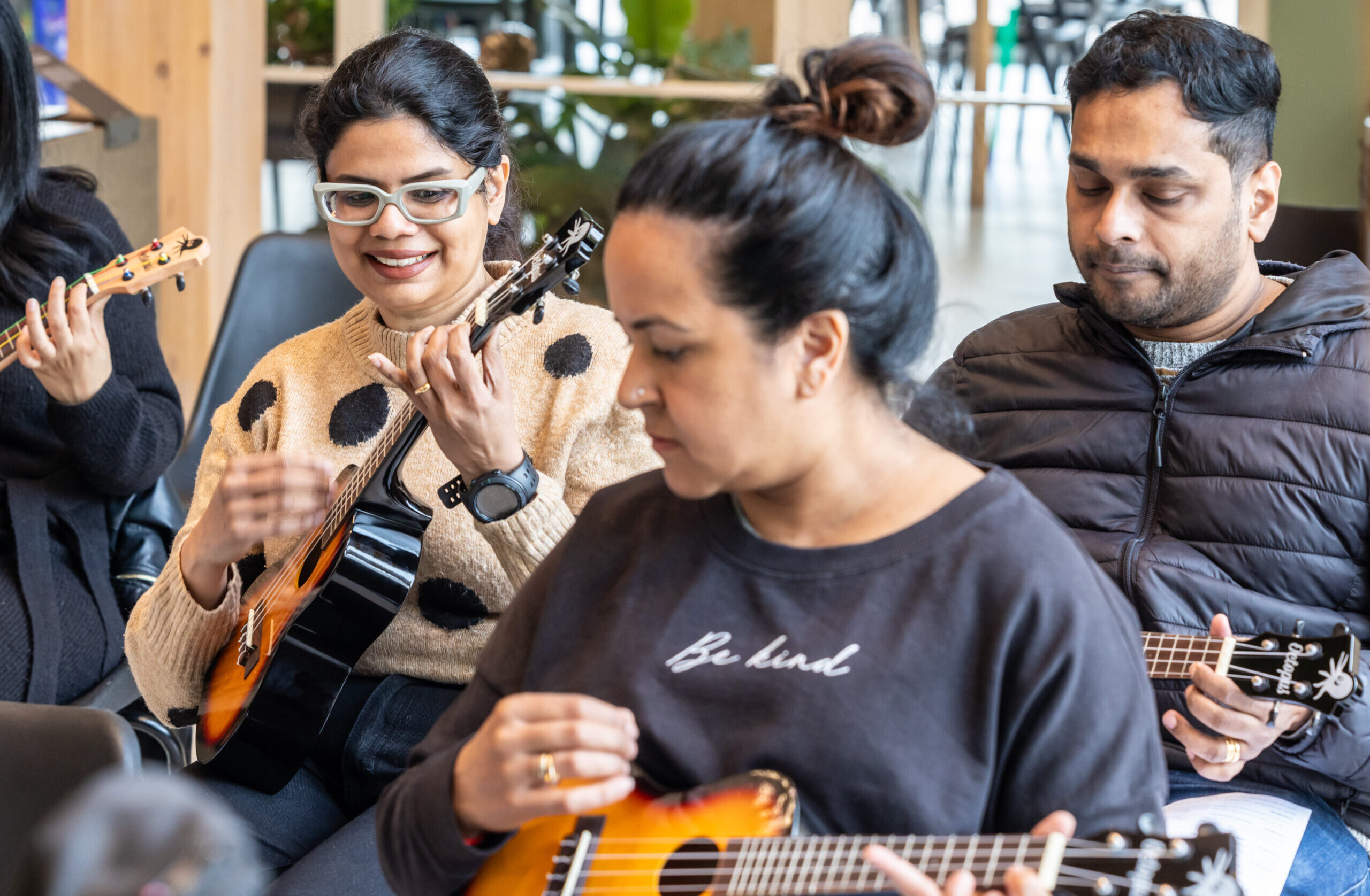 Adults playing with a Ukelele