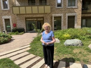 A woman standing outside a building and garden patio