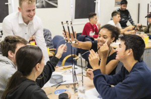 pupils gathered around and experimenting at a table