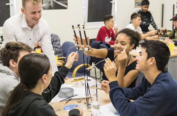 pupils gathered around and experimenting at a table