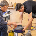 two people fixing a hoover