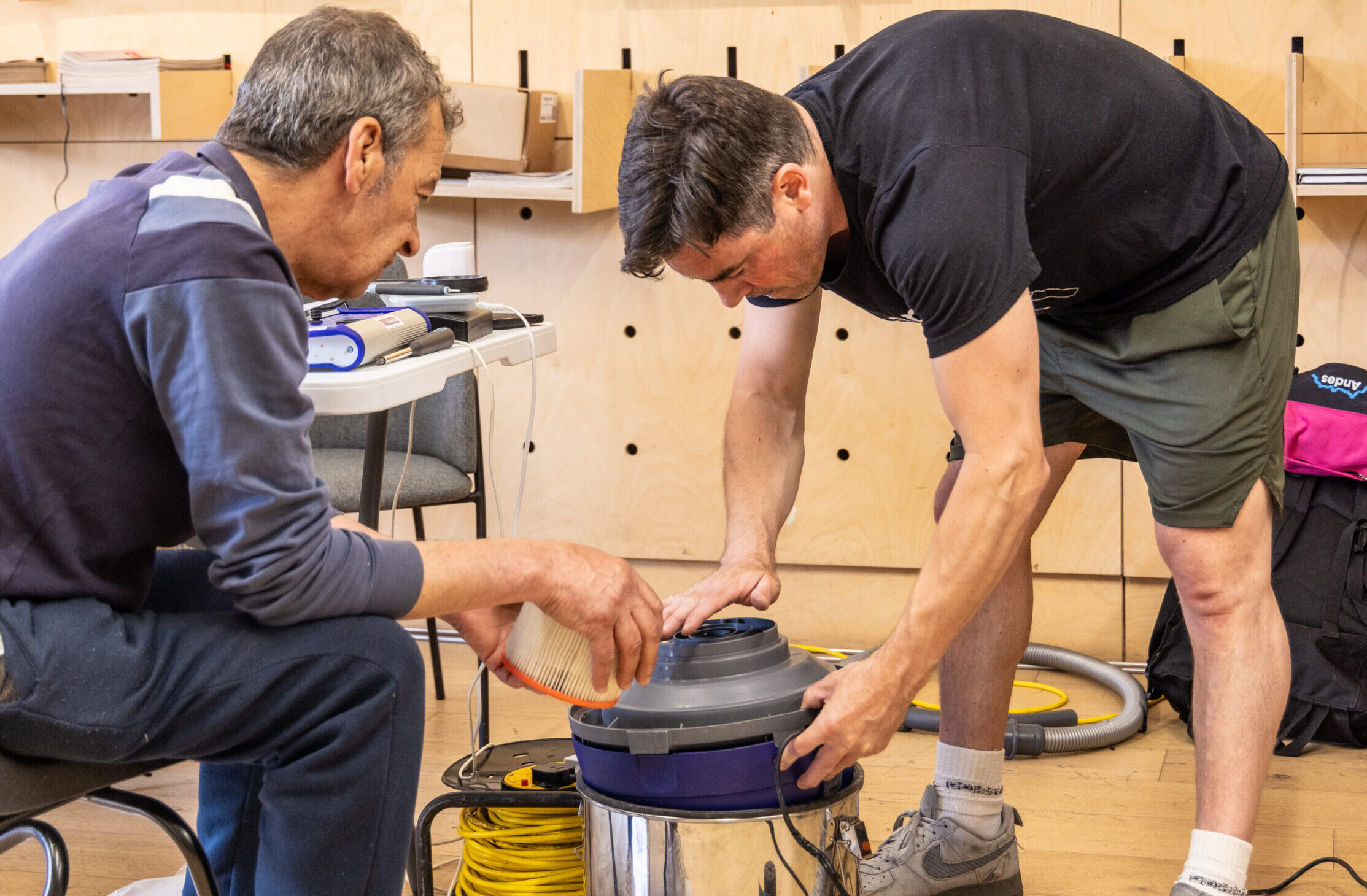 two people fixing a hoover