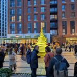 people congregating next to a green fountain and public square