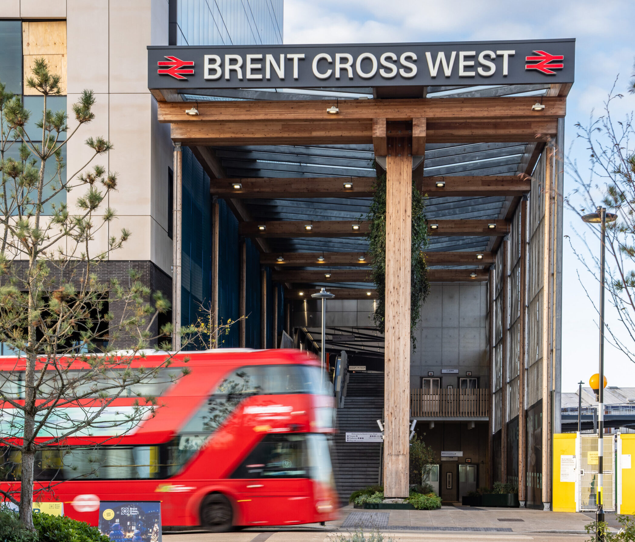 A bus passing the entrance to Brent Cross West station, Brent Cross Town