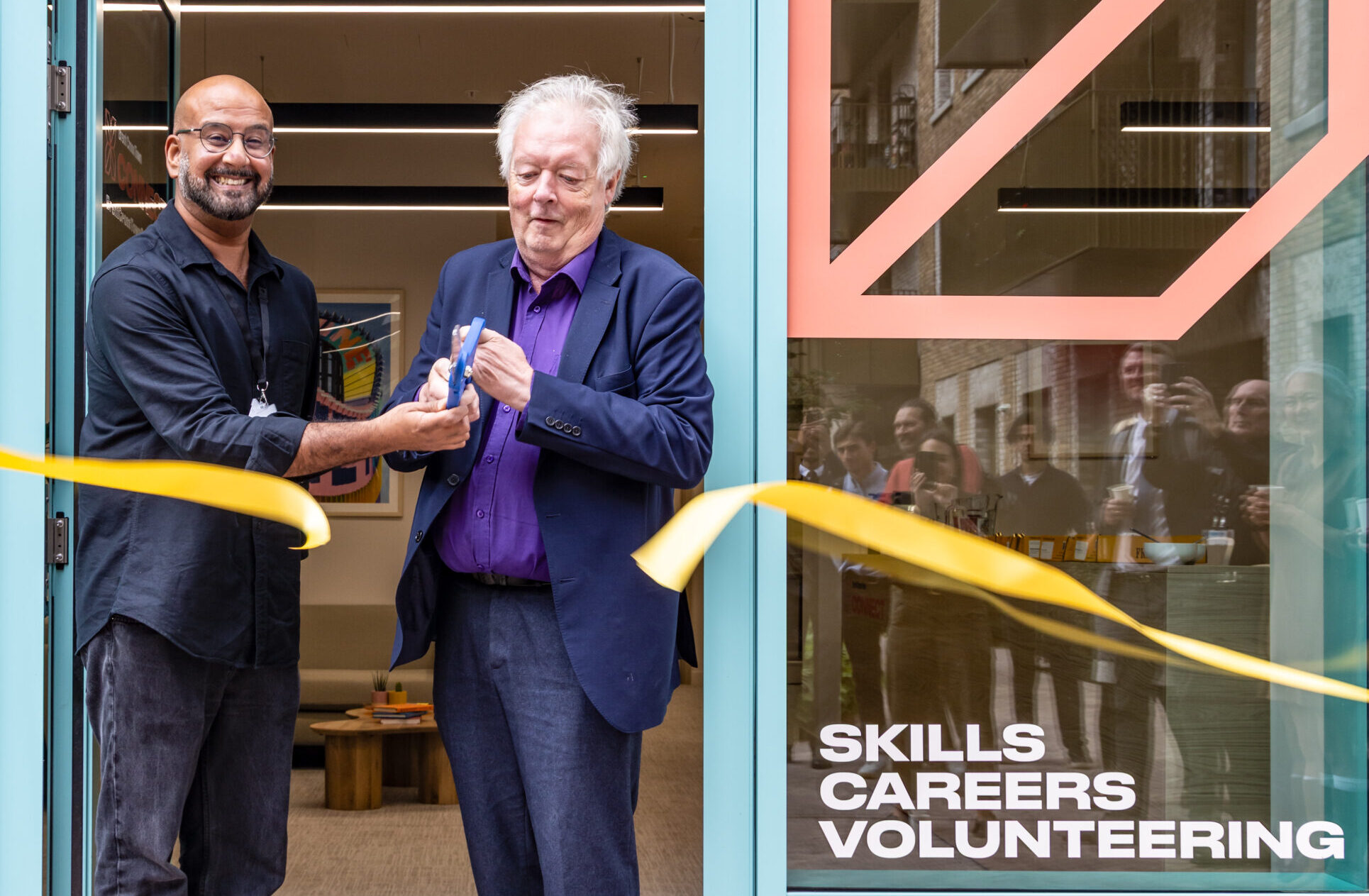 two people cutting ribbon