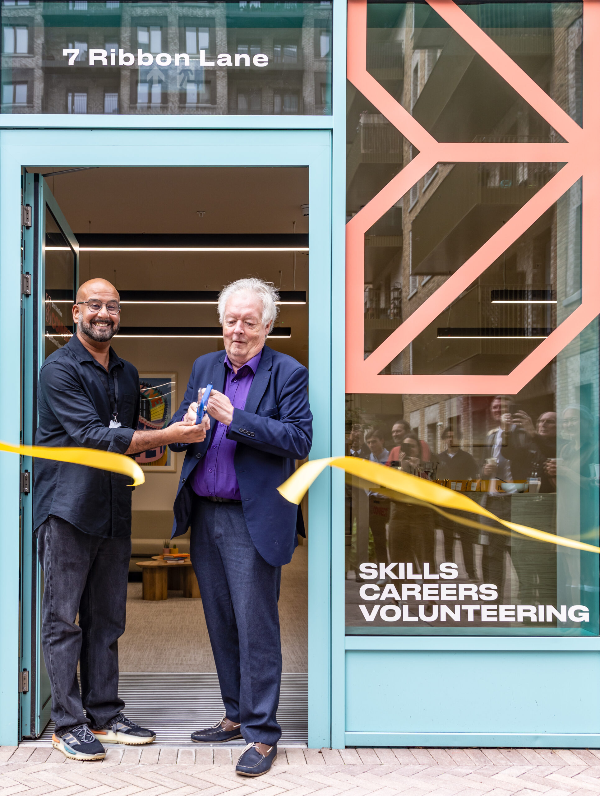 two people cutting ribbon